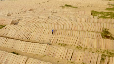 Drohnenansicht-Eines-Arbeiters,-Der-Reispapier-Auf-Dem-Reispapierdorf-In-Der-Provinz-Binh-Dinh-In-Zentralvietnam-Trocknet