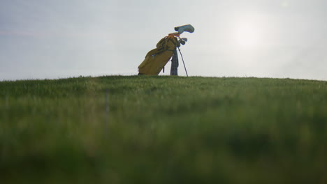 golf bag on green field under bright sky, evoking calmness and outdoor activity