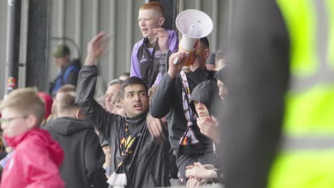 fan with megaphone leads the cheer, voice rings out, for all to hear