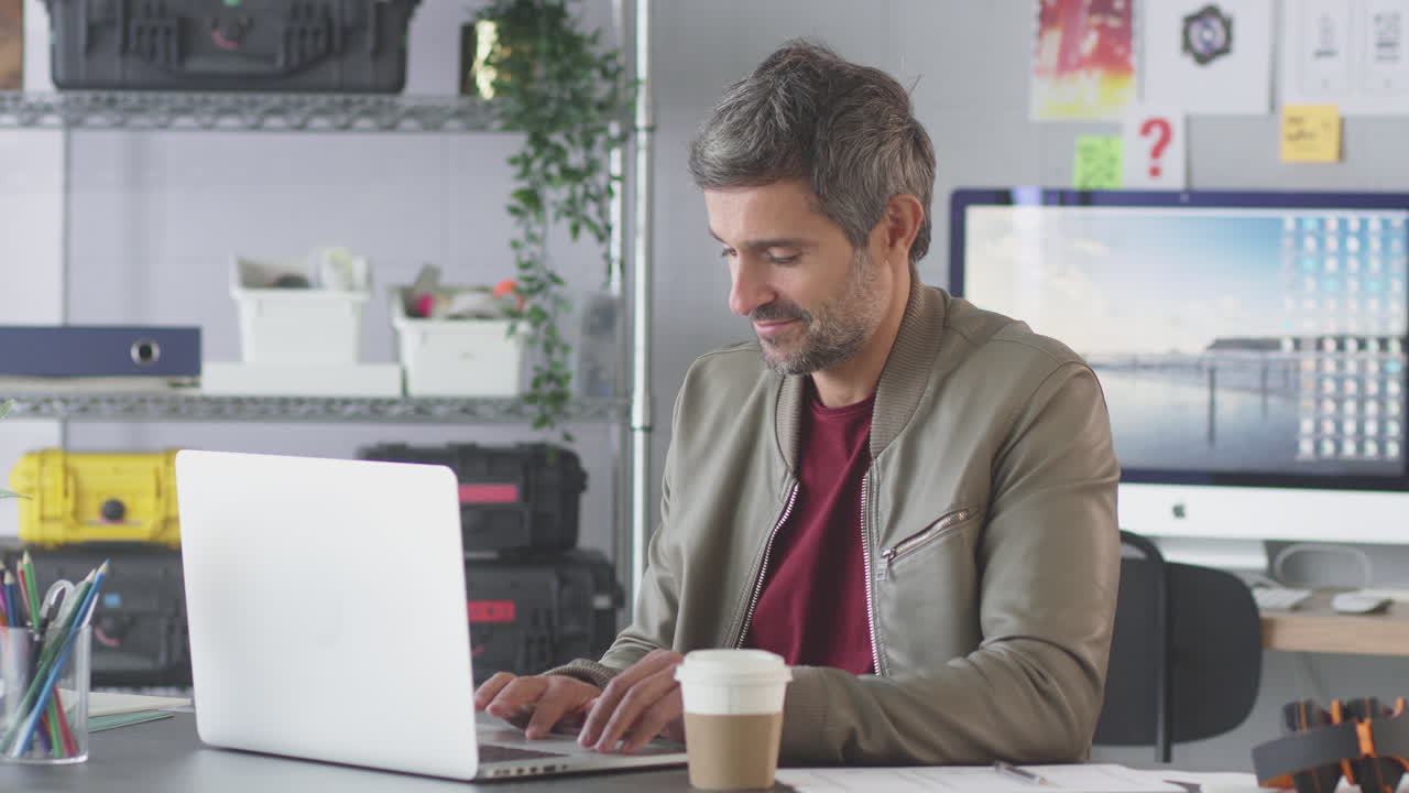 hombre de negocios maduro en una oficina creativa trabajando en un escritorio en una computadora portátil