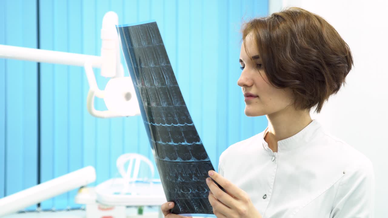 dentista examinando las radiografías dentales