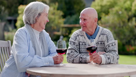 pareja de mayores, vino y mirando en el jardín