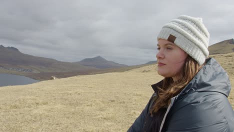 Cerca-De-Un-Medio-De-Una-Mujer-Joven-En-Las-Islas-Feroe-Con-Vistas-A-Una-Colina