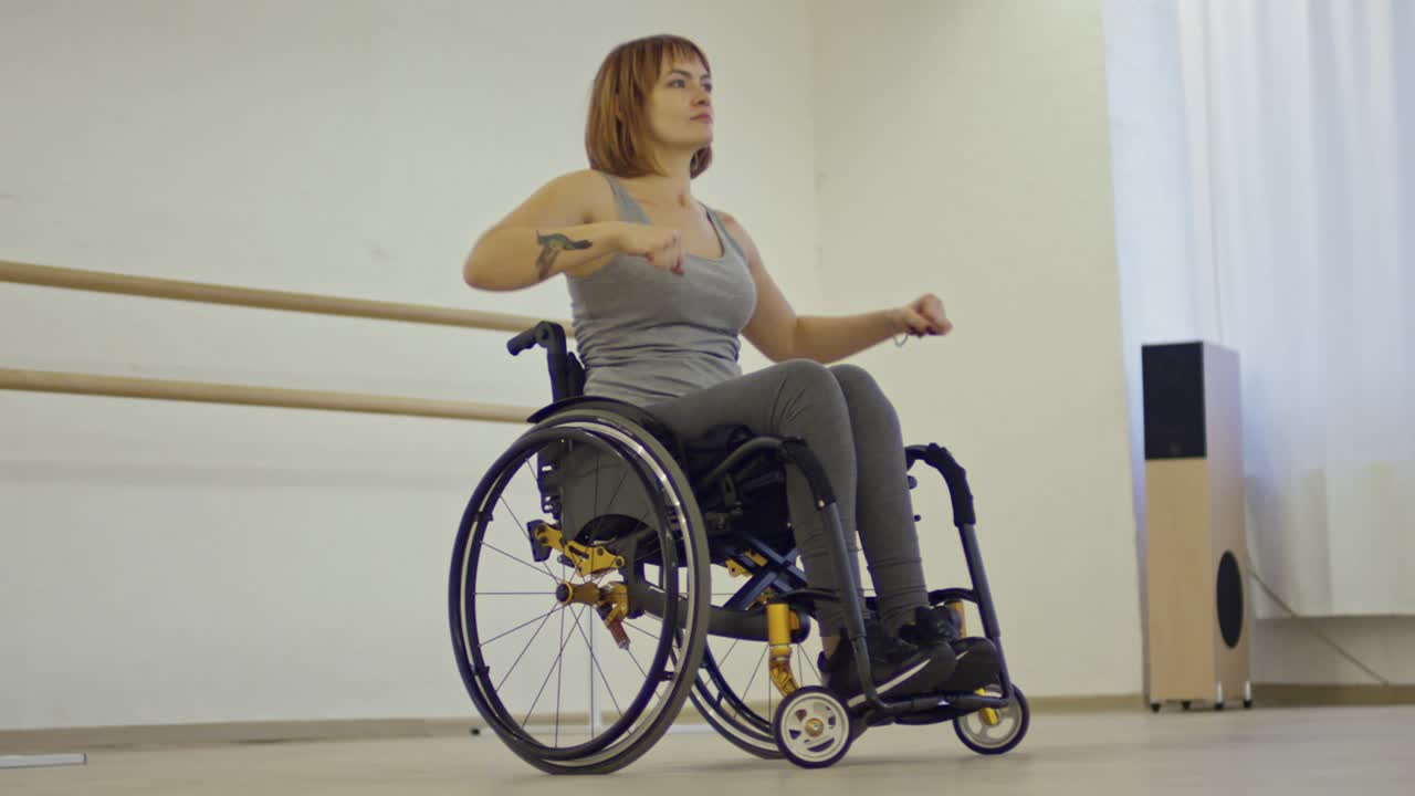 joven inspirada en silla de ruedas aprendiendo movimientos de baile