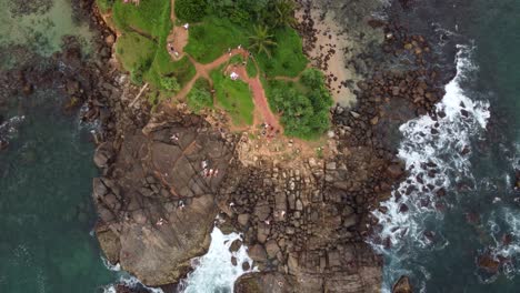 Aerial-Drone-Top-View-Over-Scenic-Tropical-Pigeon-Island-With-Lush-Green-Trees-And-Ocean-Waves-On-Rocky-Beach-Shore-In-Sri-Lanka
