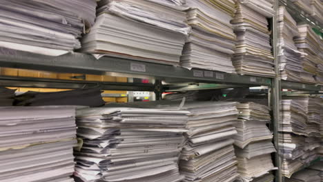 in a file archive there are shelves filled with stacks of paper