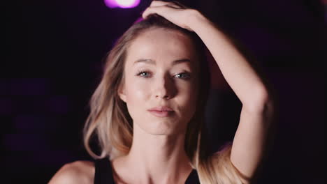 Slow-Motion-Of-Confident-Young-Woman-Moving-Hand-Through-Long-Hair-In-Gym