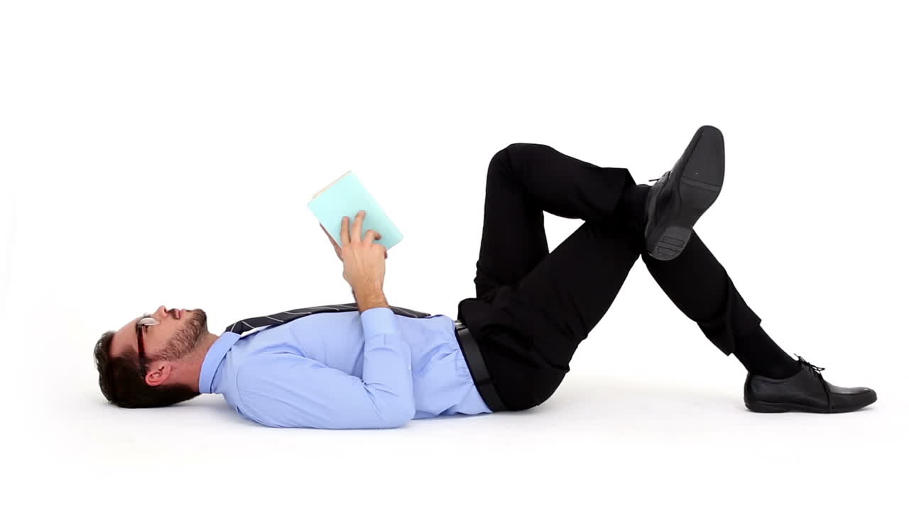 Businessman lying on floor and reading