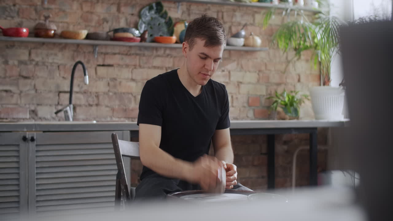 Man Working on Pottery Wheel in Kitchen