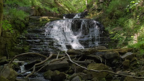 waterfall  on rocks like steps in a wood in yorkshire, gorpley clough woods