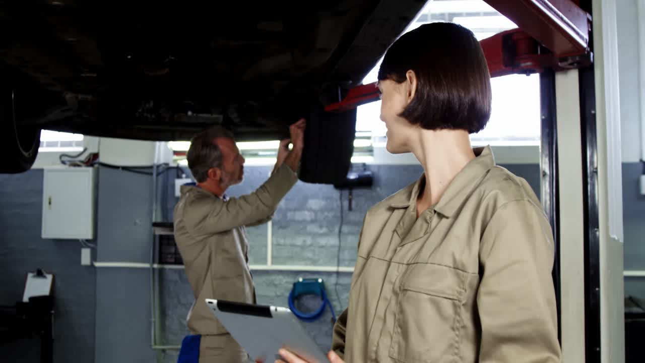 디지털 태블릿을 사용하는 동료가 바 ⁇ 를 고정하는 메카닉