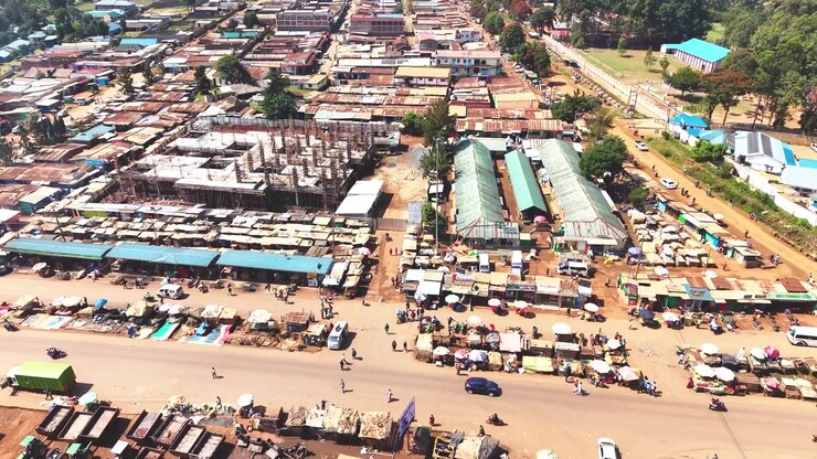 Ampia ripresa aerea che mostra lo skyline moderno di un insediamento rurale del Kenya con architetture antiche sullo sfondo e il povero distretto di baraccopoli di Kibera in primo piano