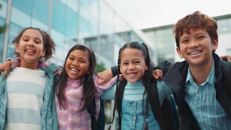 a group of happy schoolchildren are embracing outdoors