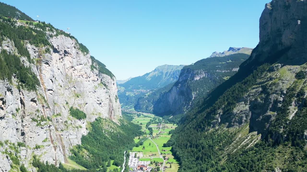 Drone flying through a valley flanked by towering mountains on both sides. Scenic aerial view, perfect for landscapes, travel, and cinematic content