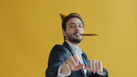 man celebrating with party hat and horn