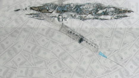 animation of a syringe falling into water over multiple american dollar bills