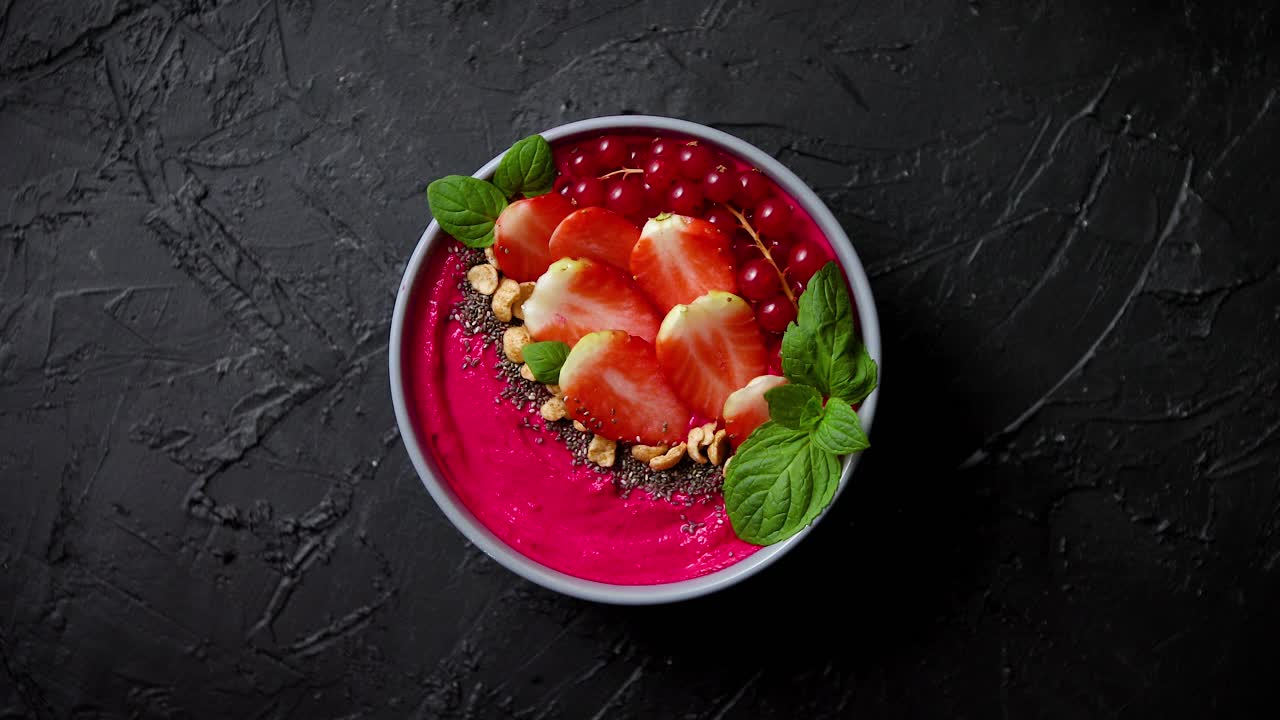 летний ягодный смузи или йогуртовый боул с клубникой красной смородиной и семенами чиа на черной основе