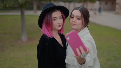 dos mujeres tomando una selfie en un parque