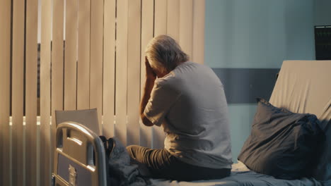 elderly patient experiencing sadness and distress in a hospital bed