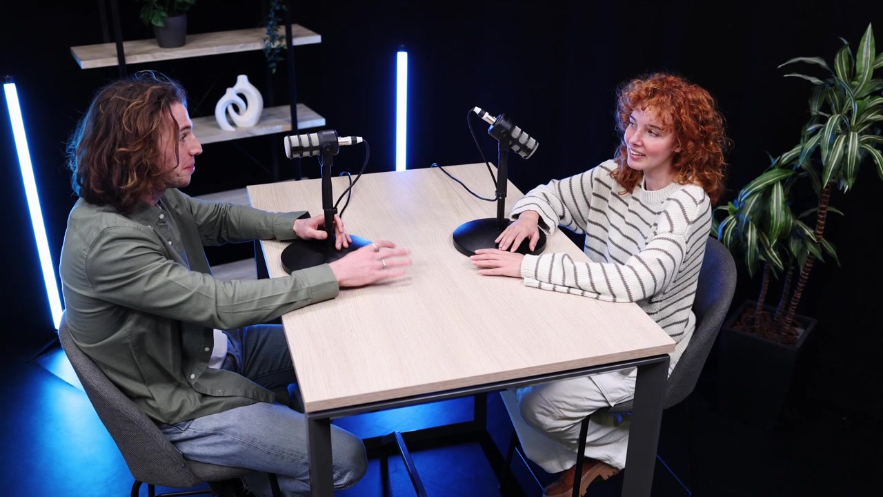 Ung mann og kvinne spiller inn en podkast i et studio