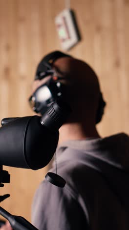 vertical video person analyzing targets shot using magnifying lens during firearm practice