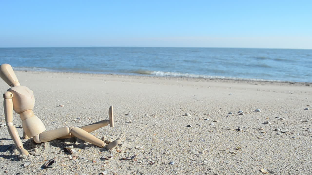 Manichino di legno sulla spiaggia. Riprese sulla spiaggia