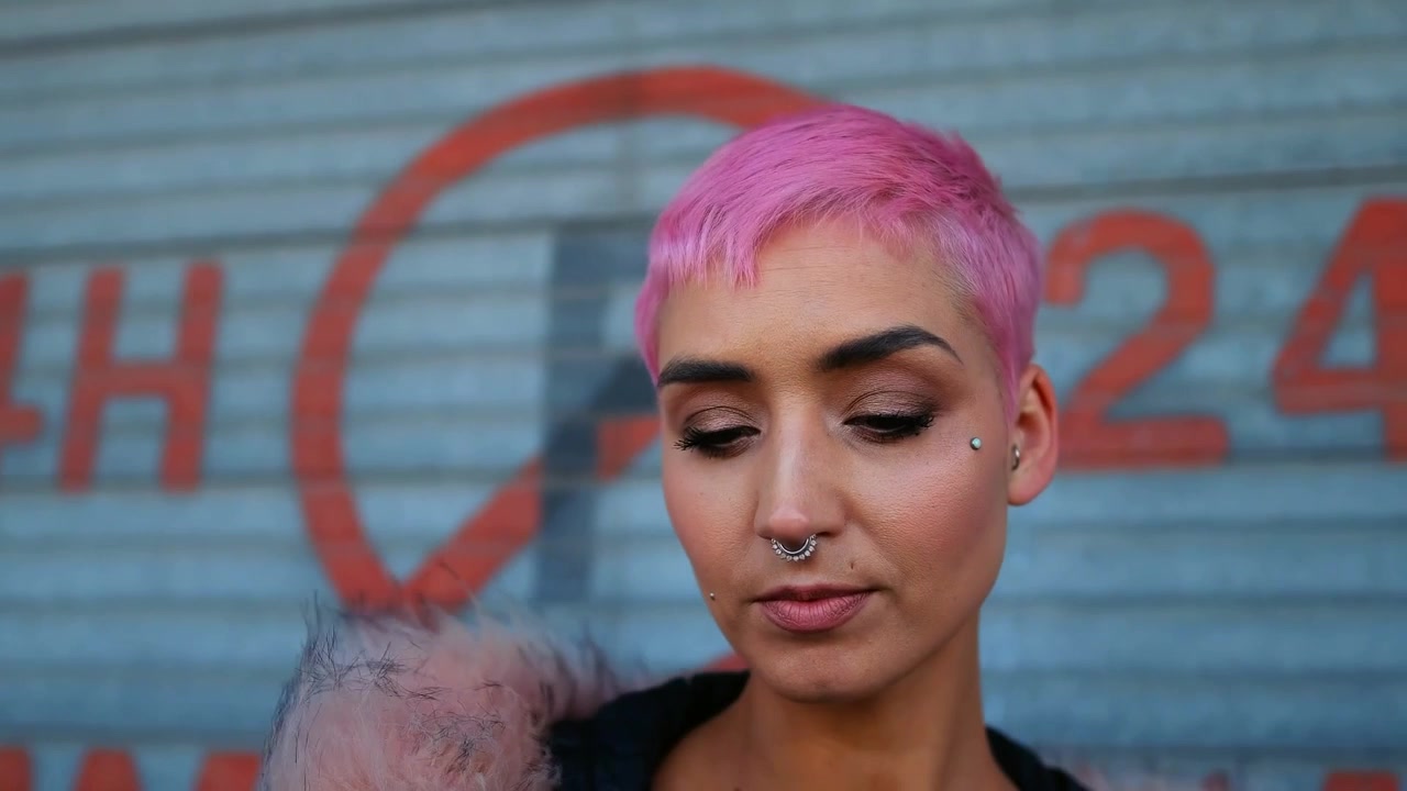 Giovane donna con capelli rosa che usa lo smartphone all'aperto