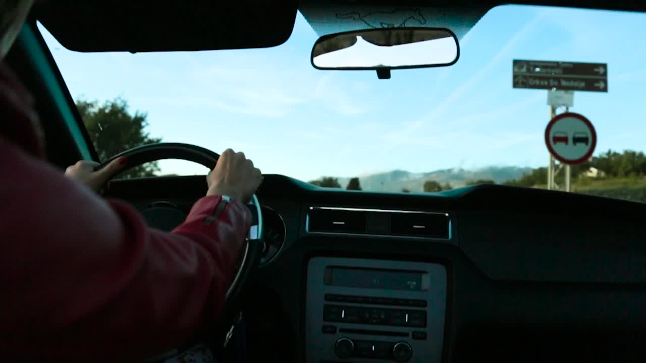 mujer conduciendo por una ruta panorámica