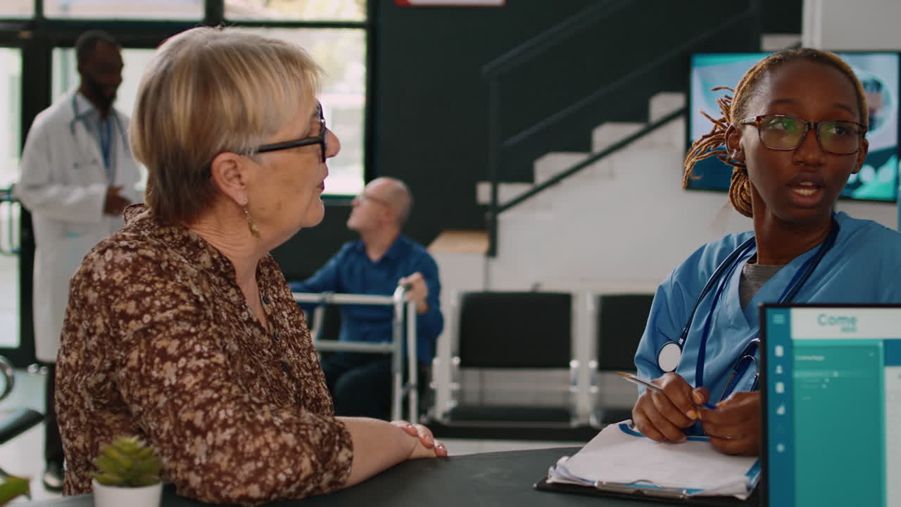 African american nurse and receptionist talking at reception counter