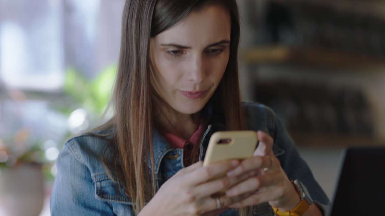 joven mujer de negocios caucásica usando teléfono inteligente en un café enviando mensajes de texto en las redes sociales trabajando en una computadora portátil digital disfrutando de la comunicación móvil