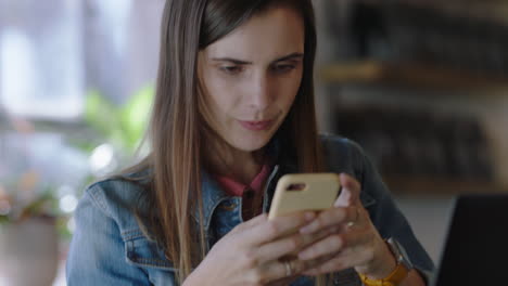 Joven-Mujer-De-Negocios-Caucásica-Usando-Un-Teléfono-Inteligente-En-Un-Café-Enviando-Mensajes-De-Texto-En-Las-Redes-Sociales-Trabajando-En-Una-Computadora-Portátil-Digital-Disfrutando-De-La-Comunicación-Móvil