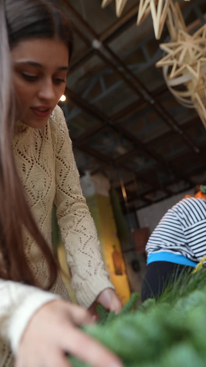 una adolescente haciendo una corona de navidad