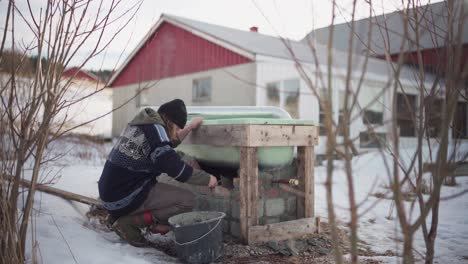 Man-Cementing-Brick-Under-Diy-Hot-Tub-Outside