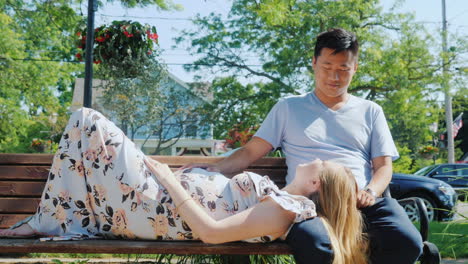 Asian-Man-With-A-Pregnant-Wife-Are-Resting-In-A-Park-On-A-Bench-Good-Time-Together