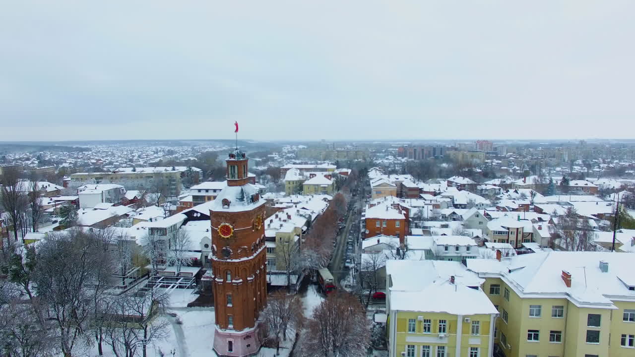 Centre of Vinnytsia, Ukraine on winter daytime. Snow covering the old tower, building tops and city streets. Aerial view.
