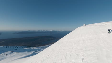 group of people summits icy mountain in fpv drone view