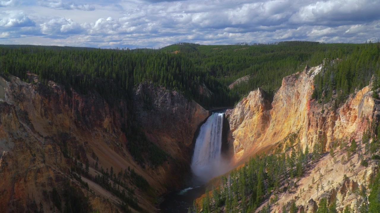Pemandangan lanskap alam Grand Canyon Yellowstone dengan air terjun bertingkat, diambil dari Titik Pandang Inspiration Point di Jalan North Rim menggunakan drone udara. Taman Nasional Yellowstone, Wyoming, menampilkan Sungai Yellowstone di pagi yang cerah dengan awan, diperbesar.