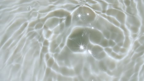 water splash. water drop creating ripple. sun and shadows. pure water with reflections sunlight in slow motion. water surface texture top view. clean swimming pool ripples and wave. 4k