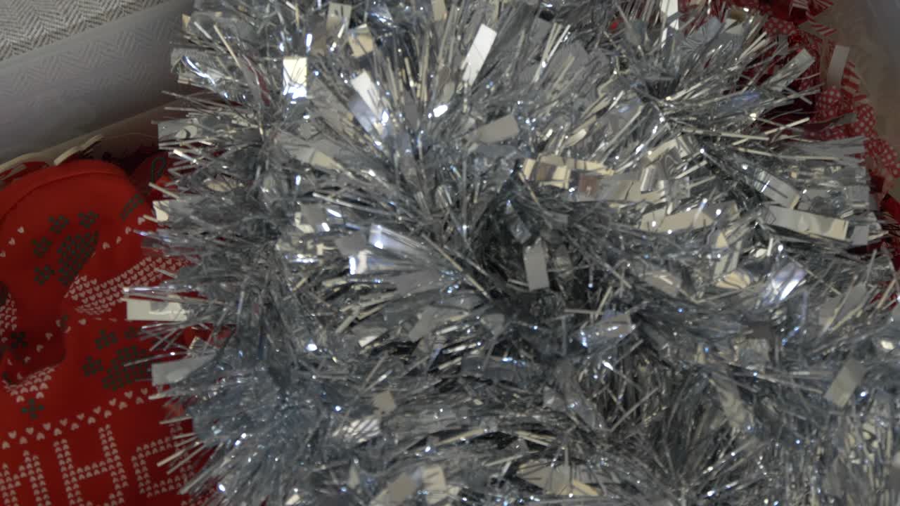 picking up christmas tinsel from a xmas decorations box