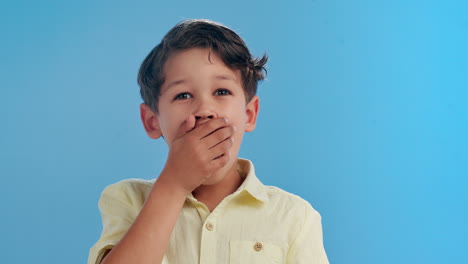 boy with hand over his mouth