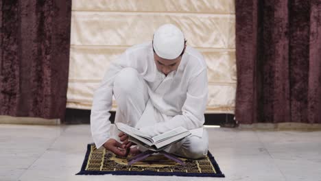 Indian-muslim-man-reading-Quran-holy-book-at-home