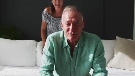 Portrait-of-happy-caucasian-senior-couple-smiling-and-talking-while-having-a-video-call-at-home