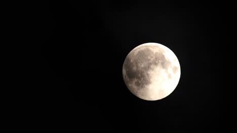 Clouds-passing-by-the-full-moon,-real-time-shot