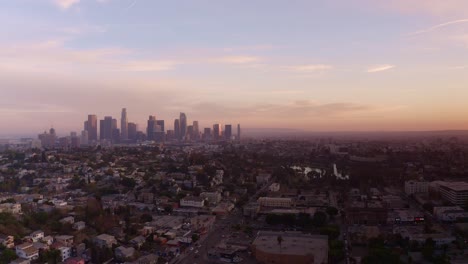 Aerial-panning-shot-of-Downtown-Los-Angeles-skyline-with-sun-setting