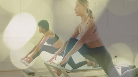 exercising on reformer machines, women focusing on fitness with bokeh lights