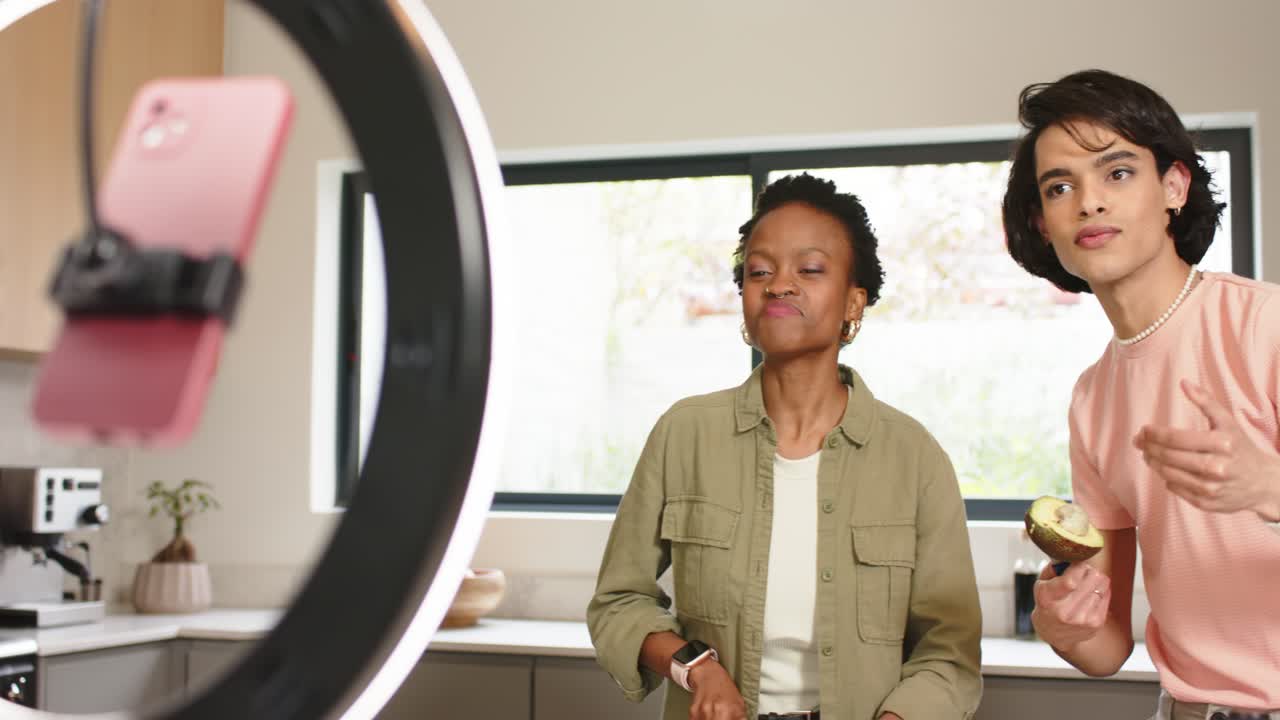 Ring light pulling focus from diverse coworkers chopping cabbage and showcasing avocado in kitchen