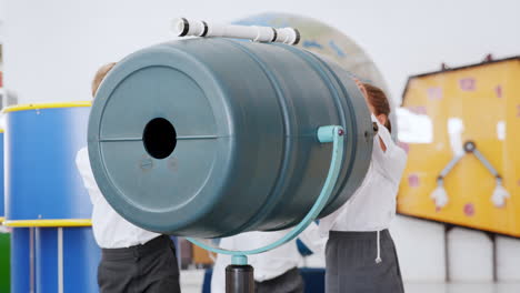 niños jugando con un cañón de aire en un centro de actividades científicas