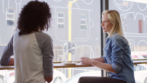 two female friends meeting in coffee shop shot in slow motion