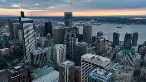 Luftaufnahme-Der-Wolkenkratzer-In-Der-Innenstadt-Von-Seattle-Bei-Sonnenuntergang-Mit-Einem-Warmen-Orangefarbenen-Schimmer-In-Der-Ferne