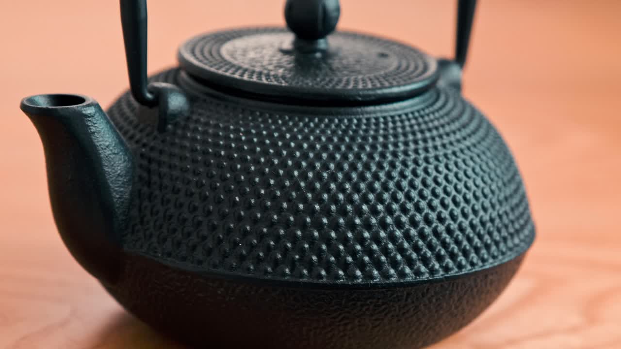 Beautiful textured, cast iron, Asian style tea pot on a wooden surface